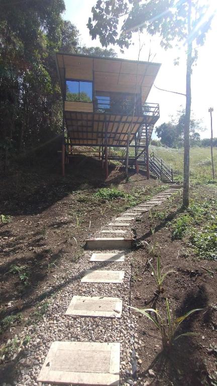 a stone walkway leading to a building in a field at La Cabaña de Jofiel in Supatá