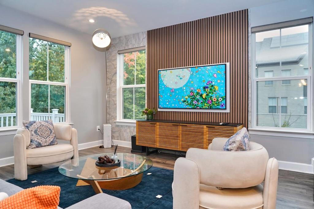 sala de estar con TV, sillas y mesa en Modern Escape Steps from FedEx Field & Near DC, en Largo