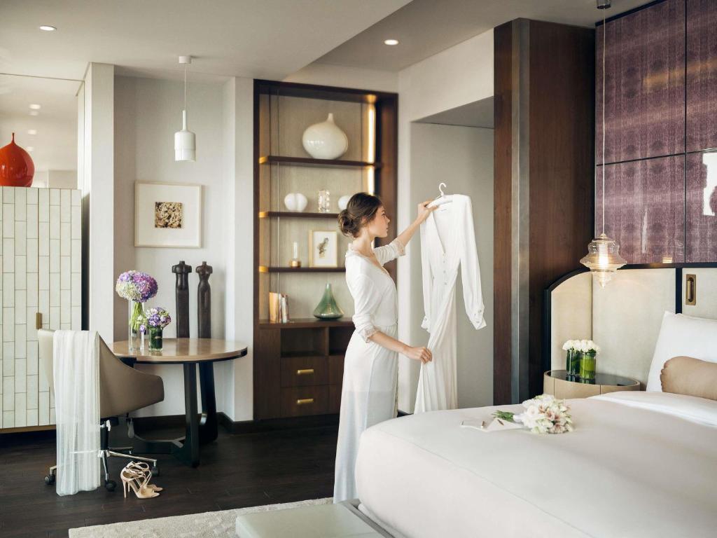 a woman in a hotel room putting on a wedding dress at Fairmont Quasar Istanbul Hotel in Istanbul