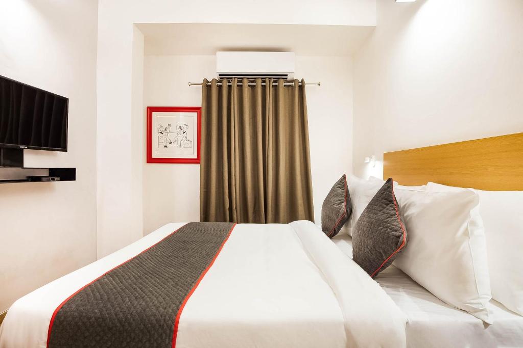 a hotel room with a large white bed with pillows at Townhouse Lords Regency in Indore
