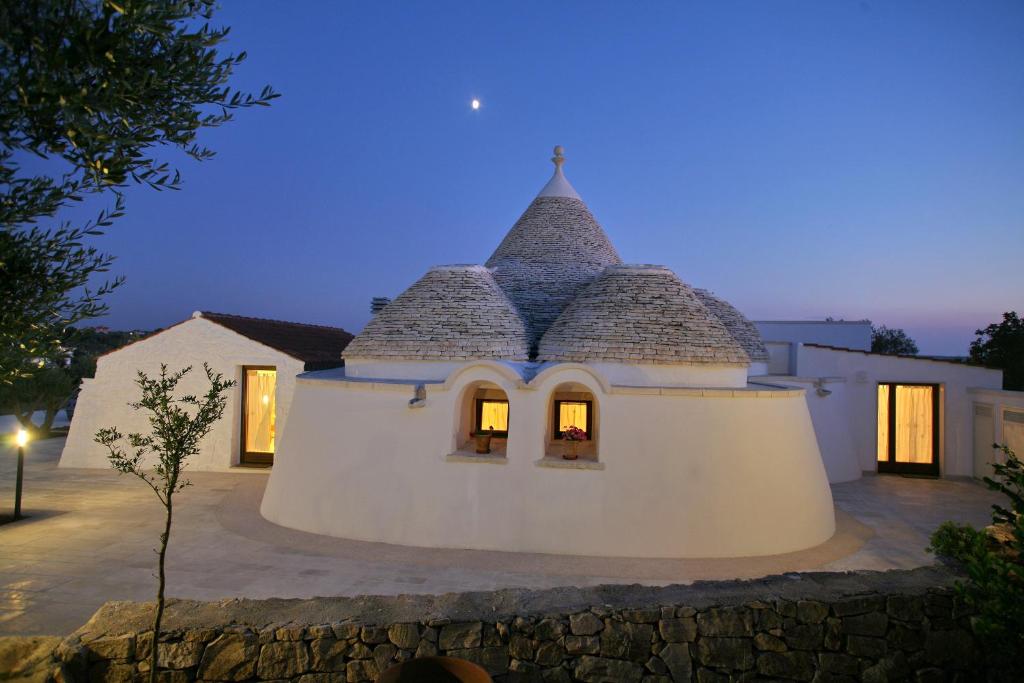 dom z dachem, który jest oświetlony w nocy w obiekcie Grotta Cilicia B&B w mieście Noci