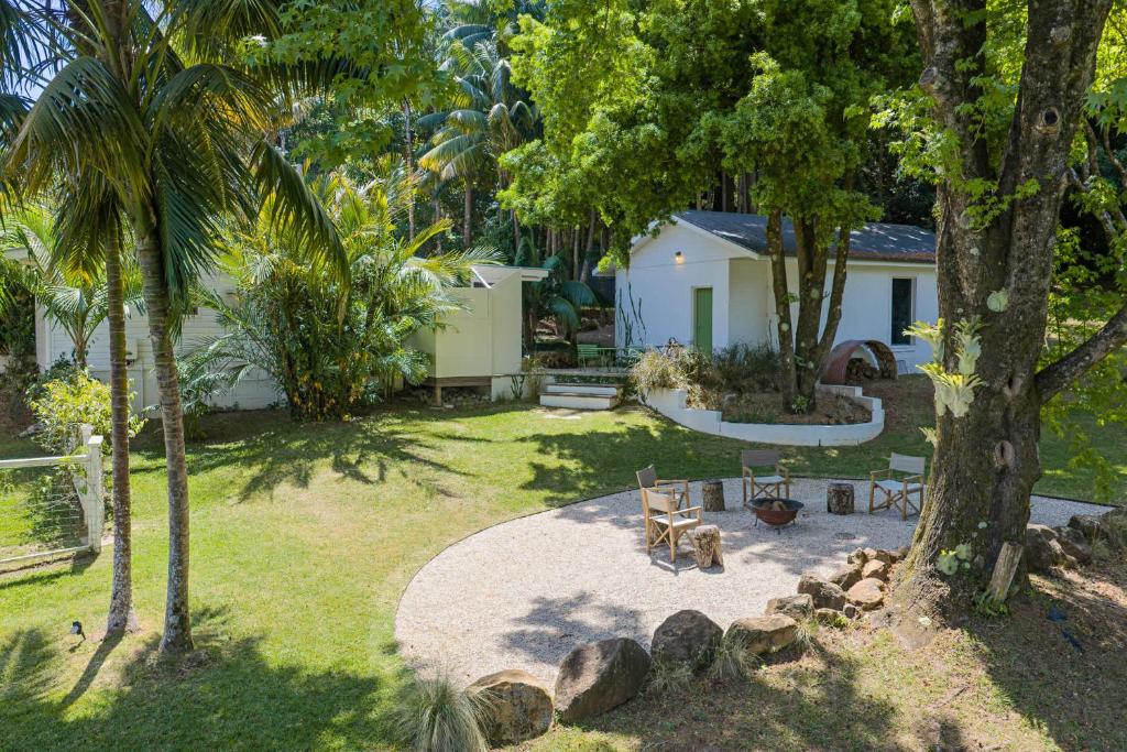 a yard with trees and a house with a patio at Byron Hinterland Hideaway l Firepit l Nova Escapes in Goonengerry
