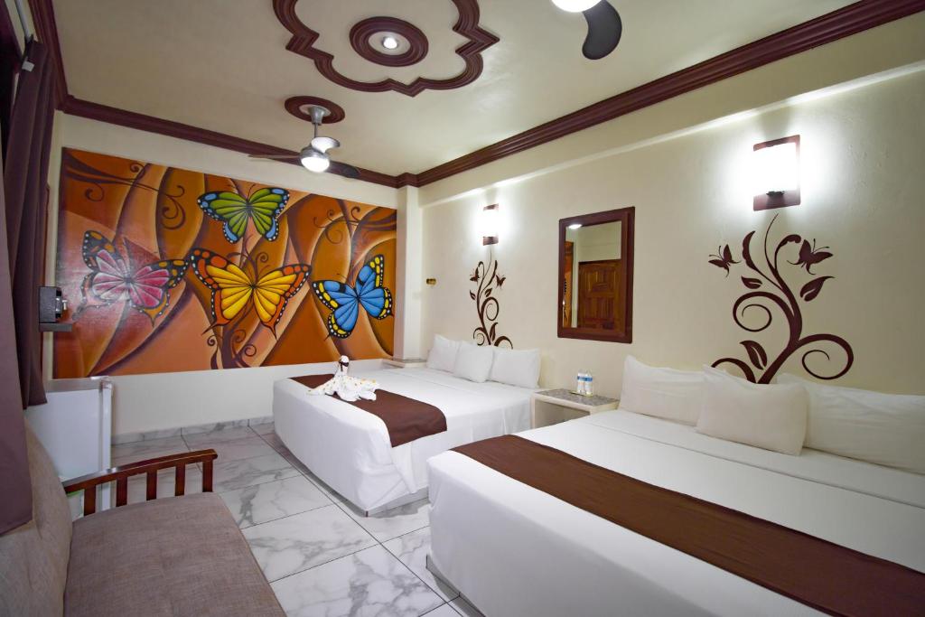 una camera con due letti e un dipinto sul muro di Hotel Diamante a Santa Cruz Huatulco