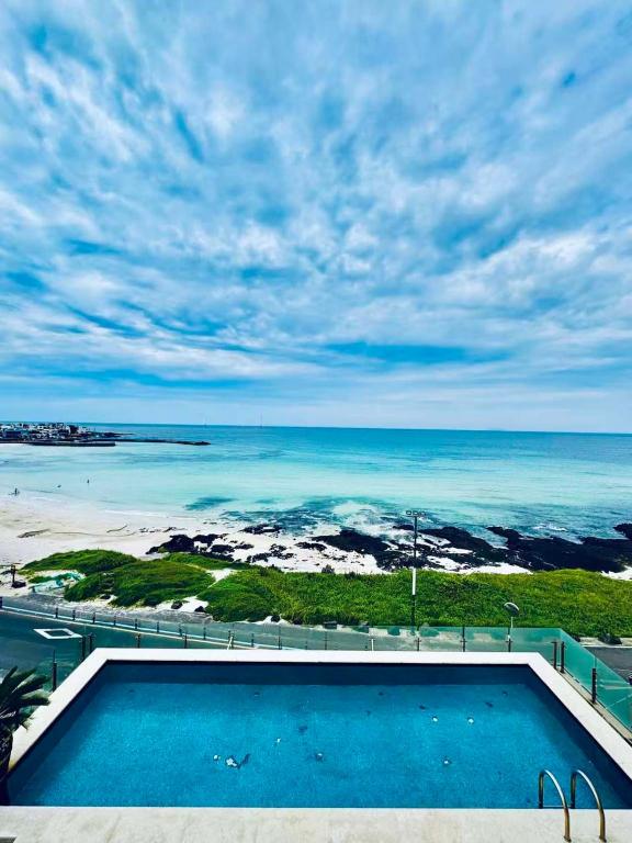 a swimming pool with a view of the ocean at Xinsu Woljeongli in Jeju