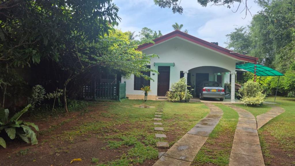 a small house with a car parked in the yard at The Green Weligama in Weligama