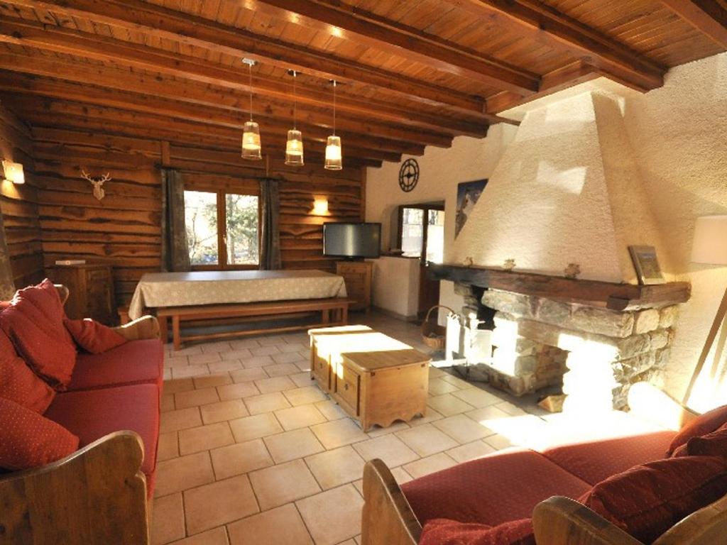 un salon avec un canapé et une cheminée dans l'établissement Chalet 10p avec Jardin, Proche Pistes, Wi-Fi, Cheminée - La Salle-les-Alpes - FR-1-762-49, à Le Bez