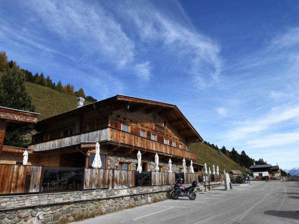 a wooden building with a motorcycle parked in front of it at Chalet in Zillertal near Hochzillertal Ski Area in Zellberg