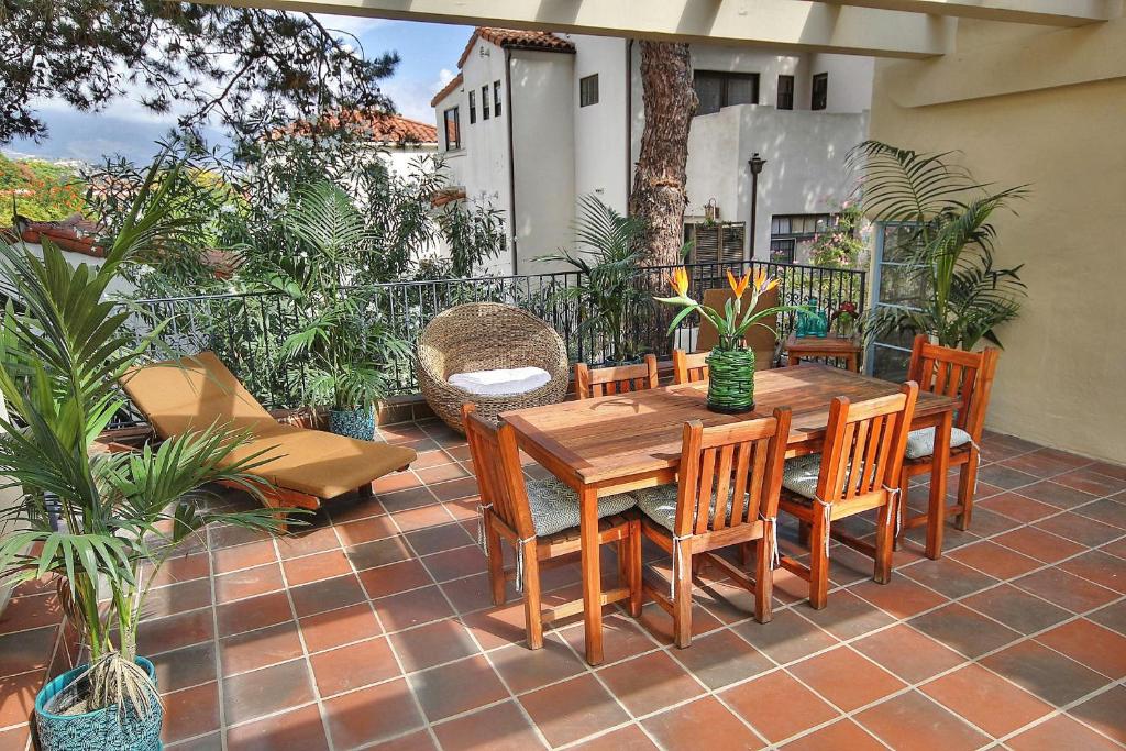 Una mesa y sillas de madera en un patio. en West Beach Villa 1, en Santa Bárbara