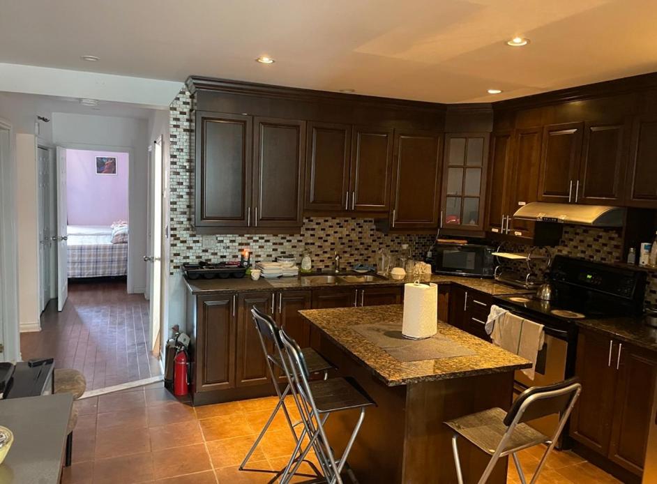 a kitchen with wooden cabinets and a counter top at 2 Beds availabe and self service small breakfast in Montréal