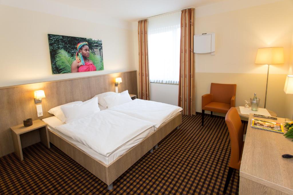 ein Hotelzimmer mit einem großen Bett und einem Stuhl in der Unterkunft Saterländer Hof in Ramsloh