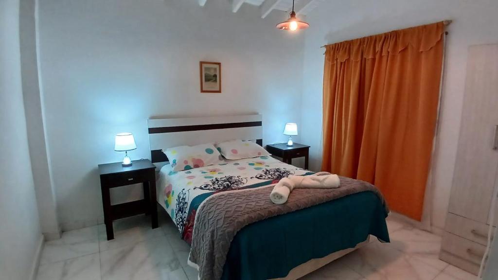 a bedroom with a bed with two night stands and two lamps at Artin House Mendoza in Ciudad Lujan de Cuyo