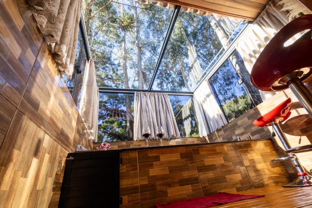 a room with a large window in a house at Cabana Pequeno Bosque Refúgio dás Águas in São Joaquim