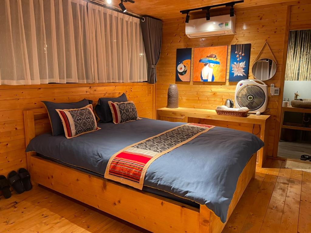 a bedroom with a bed in a log cabin at Son Bá Mười Ecolodge 