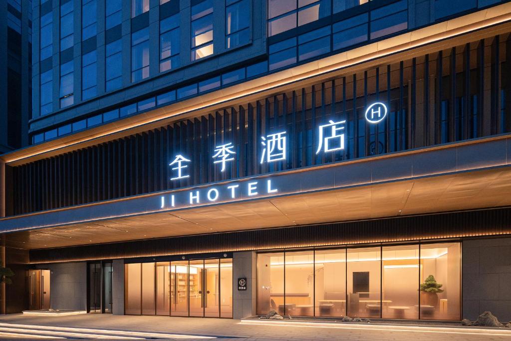 a hotel with a sign on the side of a building at JI Hotel Qingdao Haier Industrial Park Wannianquan Road Subway Station in Qingdao