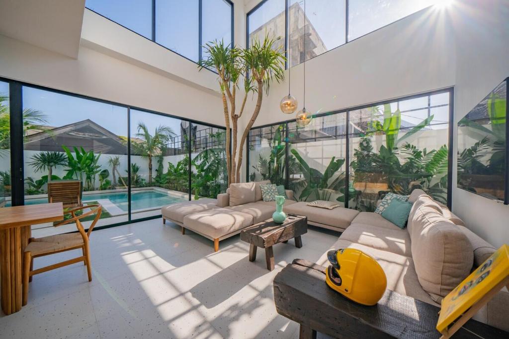 ein Wohnzimmer mit Sofa und Tisch in der Unterkunft Luxury 4BR Villa Private Pool & Sea Horizon in Kerobokan