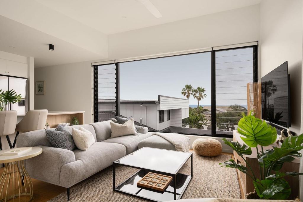 Sophisticated Beach Abode في بيرجيان بيتش: غرفة معيشة مع أريكة ونافذة كبيرة