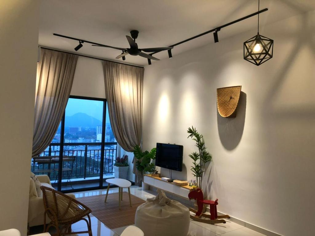 a living room with a couch and a tv and a room with a window at Yuru House - The Horizon Ipoh in Ipoh