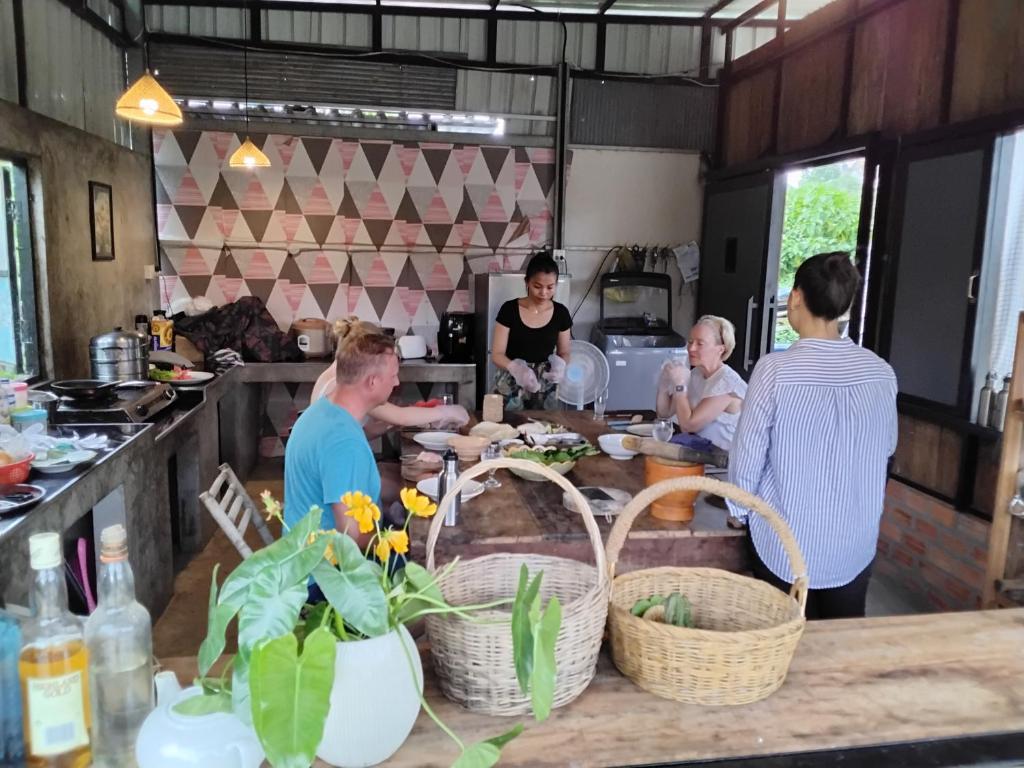 a group of people in a kitchen preparing food at Battambang Eco Stay &cooking class in Battambang