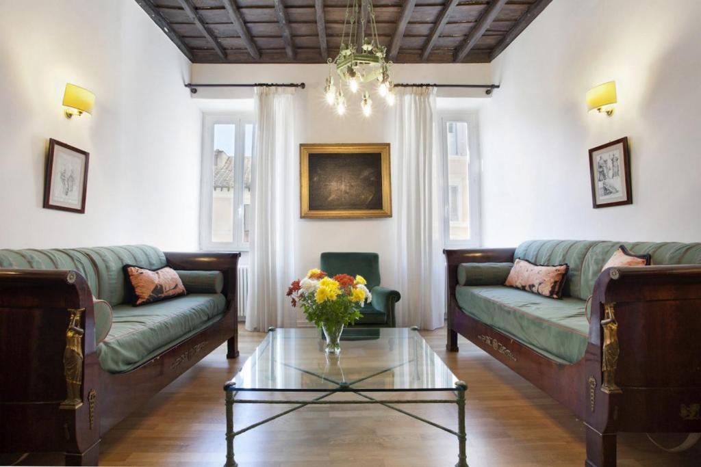 een woonkamer met 2 banken en een glazen tafel bij Locappart Colosseo / Esquilino in Rome