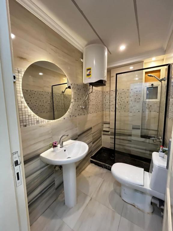 a bathroom with a sink and a toilet and a mirror at Histogram home in Cairo