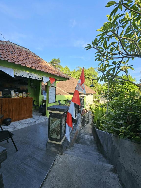 Un edificio con banderas rojas y blancas en una acera. en green view downtown, en Ubud