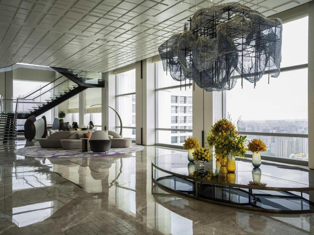 a lobby with a chandelier and a living room at Sofitel Haikou in Haikou