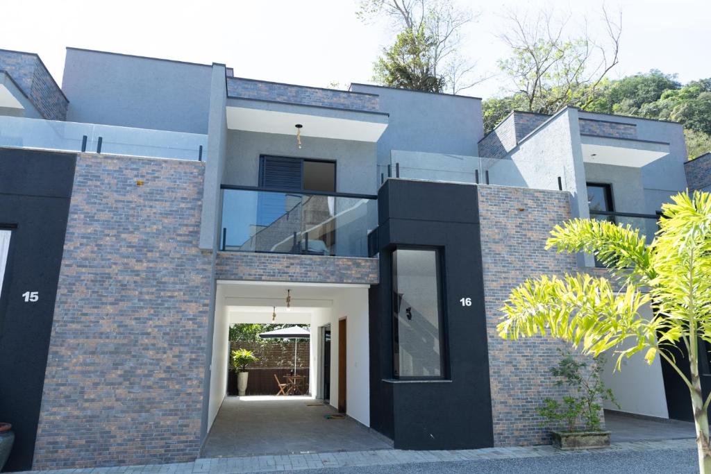 ein modernes Haus mit einer schwarz-weißen Fassade in der Unterkunft Casaboa Paúba in São Sebastião