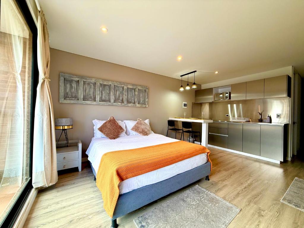 een slaapkamer met een groot bed en een keuken bij Loft Elegante y Centra en Bogotá in Bogota