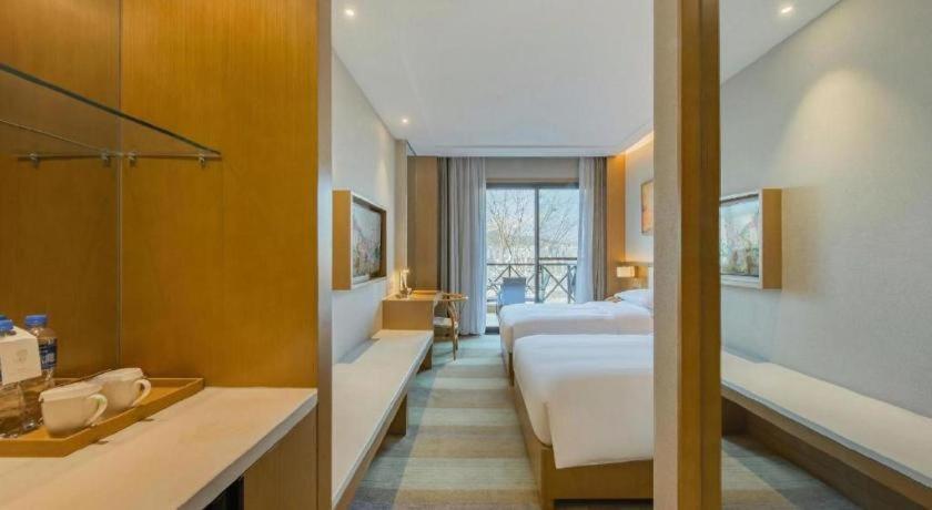 a hotel room with a bed and a bathroom at Deefly Yinrun Town Hotel in Deqing