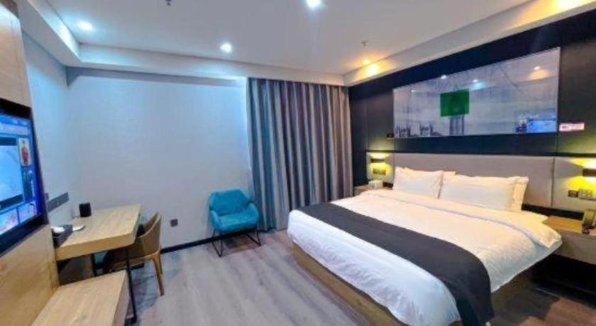 a bedroom with a bed and a desk and a television at UP and IN Hotel Jiangsu Xuzhou Gulou District Lvdizhichuang in Xuzhou