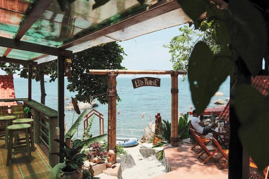 a view of the ocean from a patio with a sign at Ecohouse Hòn Sơn in Lai Sơn