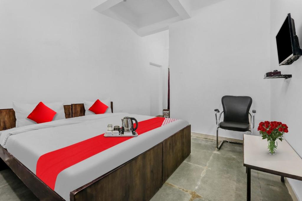 a bedroom with a large bed and a chair at Hotel O Star Stay Guest house opposite Kendriya Bhawan in Lucknow
