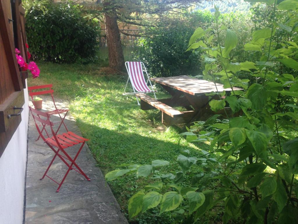 BozelにあるVacances COURCHEVEL/les 3 Valléesの庭園内の椅子2脚とピクニックテーブル