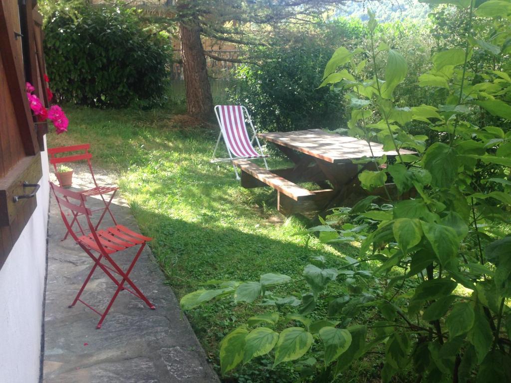 - deux chaises et une table de pique-nique dans le jardin dans l'établissement Vacances COURCHEVEL/les 3 Vallées, à Bozel