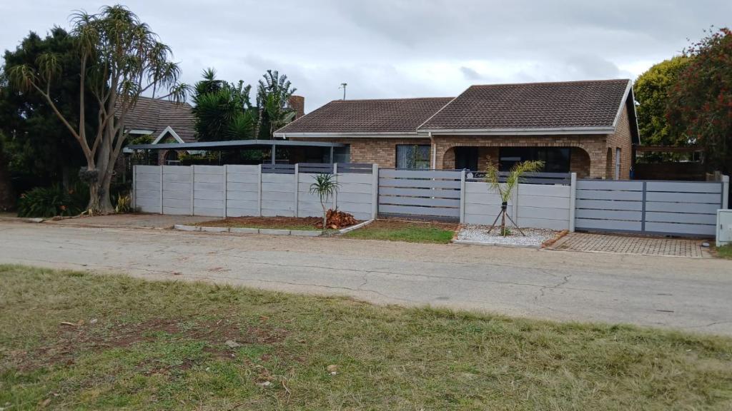 a white fence in front of a house at JT Surfhouse in Jeffreys Bay