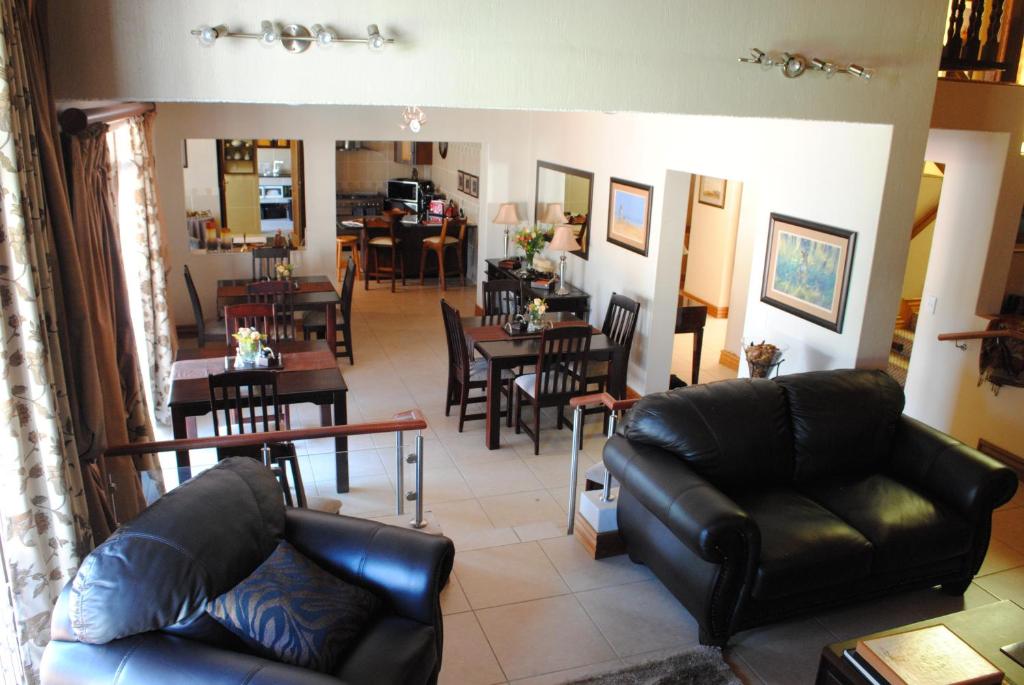 a living room with a couch and a dining room at 125 on Van Buuren Road Guest House in Johannesburg