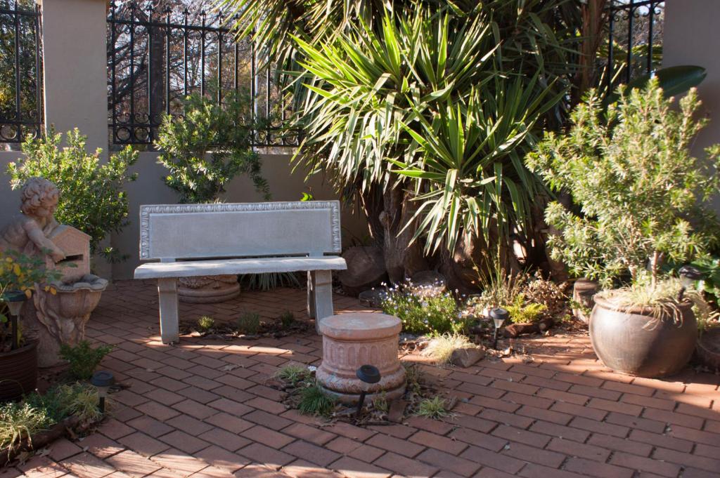 a bench sitting in the middle of a garden at 125 on Van Buuren Road Guest House in Johannesburg