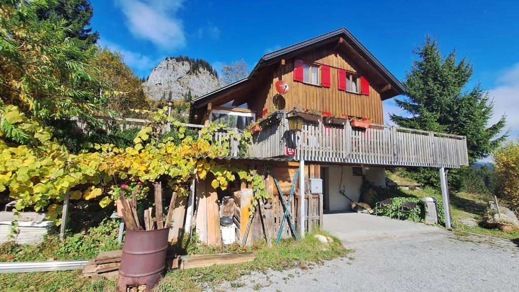 a wooden house with red windows and a balcony at Haus Susi in Dornbirn