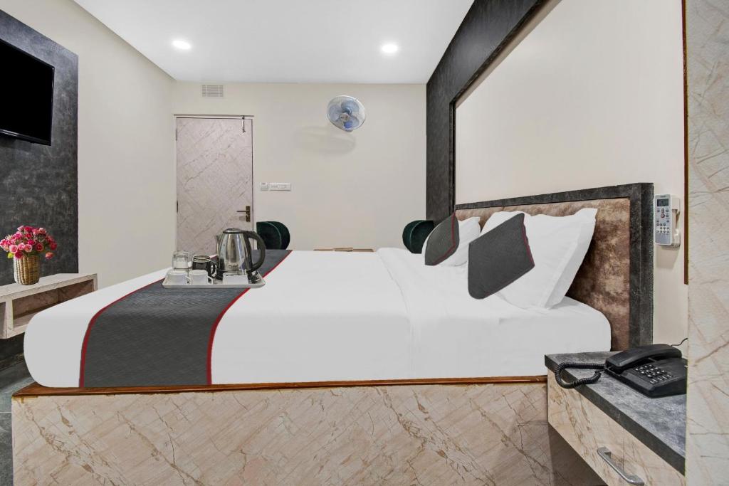 a bedroom with a large white bed and a sink at Townhouse OAK Hotel Rudra in Jaipur