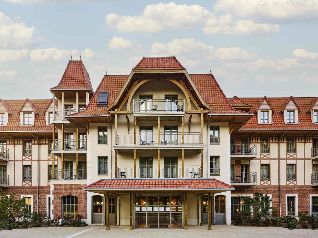 a large building with red tile roofs at TRIBE Hôtel Le Touquet in Le Touquet-Paris-Plage