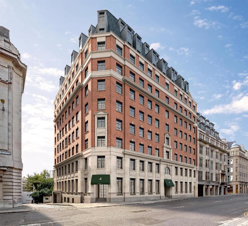 a large brick building on a city street at The Derby London City, Curio Collection By Hilton in London