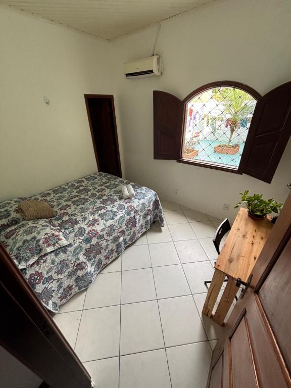 un dormitorio con una cama y una ventana en Aquiri Hostel, en Rio Branco