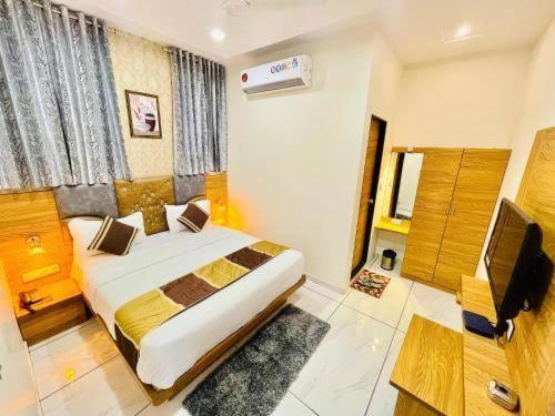 a bedroom with a bed and a television in it at HOTEL SUN town in Ahmedabad