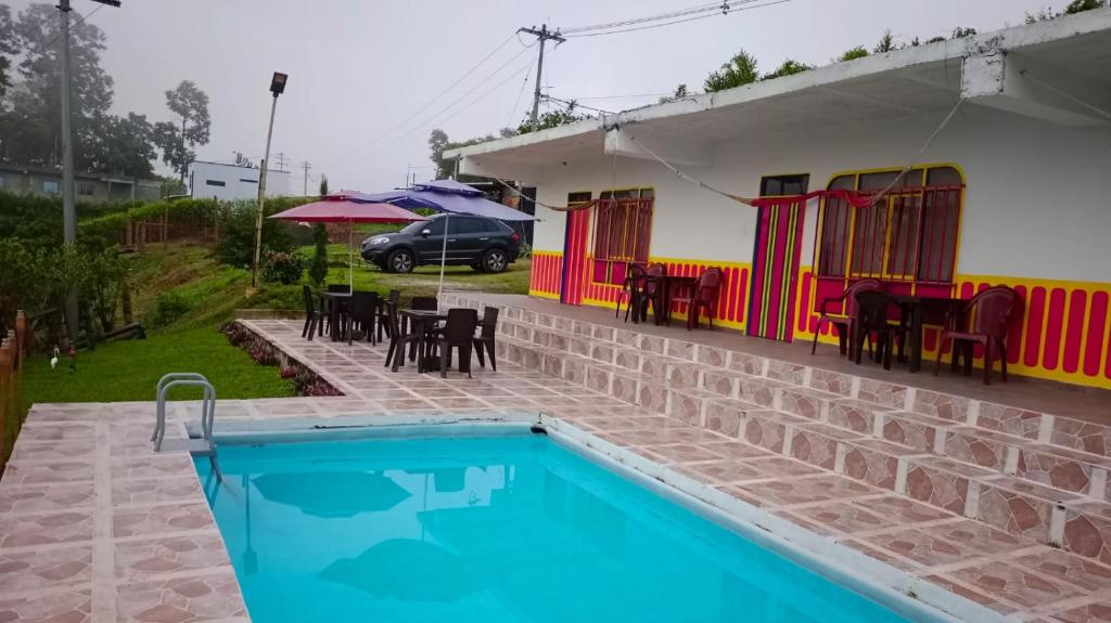 a house with a swimming pool and a table and chairs at Finca El Turpial in Alcalá