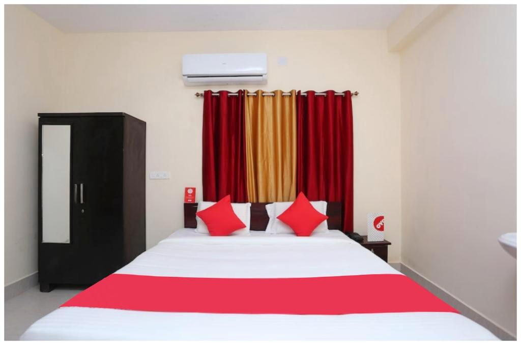 a bedroom with a bed with red and yellow curtains at Hotel Moonlight Palace Near Patia Railway Station-Fully Air Conditioning Hotel - Luxury & Spacious Room -A Premium Hotel in Cuttack