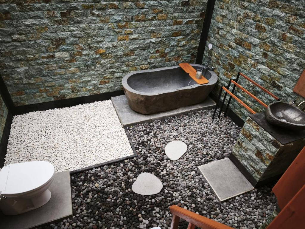 a bathroom with a bath tub and a toilet at Arta dani villas in Sidemen