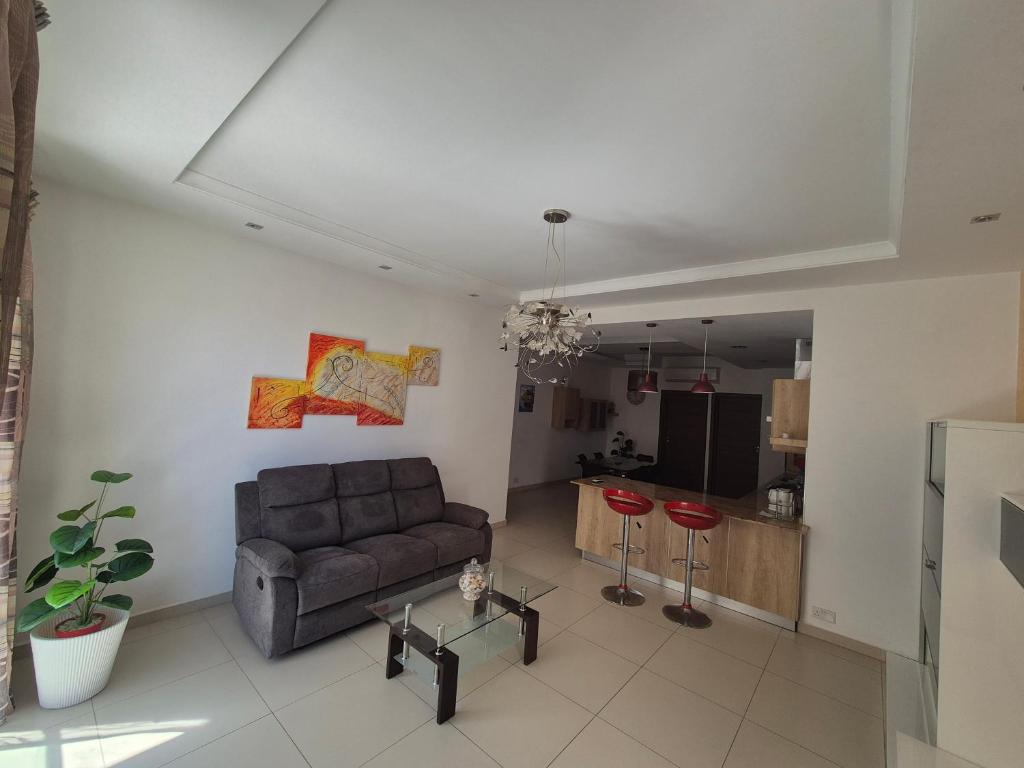 a living room with a couch and a table at LA court in Marsascala in Marsaskala