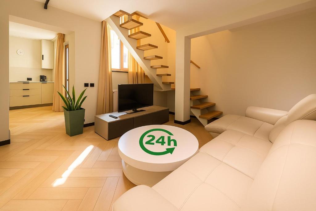 a living room with a white couch and stairs at Origin Central Apartment in Cluj-Napoca