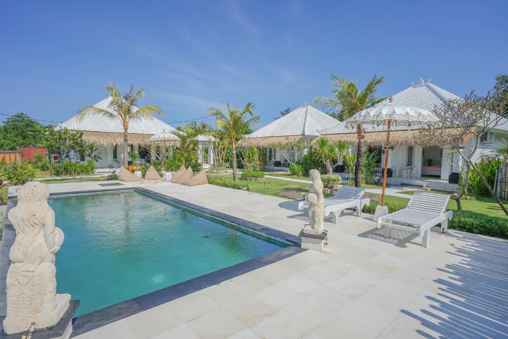 a swimming pool with two chairs and a house at Sukacita Hill in Uluwatu
