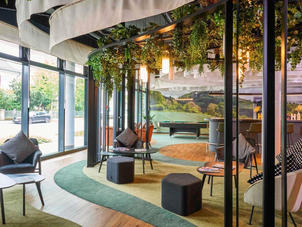 a lobby with chairs and tables and windows at Ibis Styles Singen 24h geöffnet in Singen